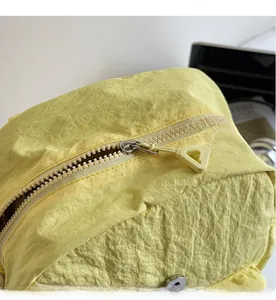 Close-up detail of smooth plastic zipper on high-capacity yellow canvas backpack
