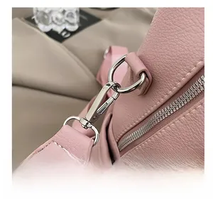 Detailed close-up of premium silver metal hooks and zippers on a pink leather backpack