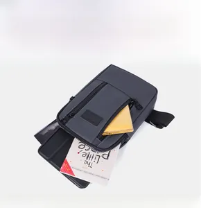 Internal compartments of gray washed denim sling bag showing space for tablets and books