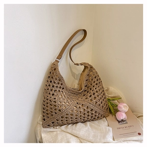 Detail of hand-woven straw tote bag with brown leather strap and hollow weave texture
