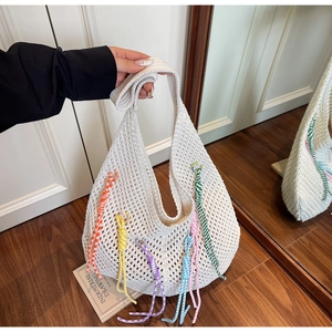 Detail of bohemian cream crochet tote bag with colorful tassels and hollow out design