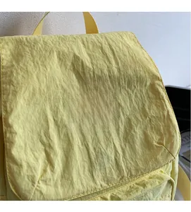 Close-up of yellow wrinkled nylon fabric and waswac rules logo on a student backpack