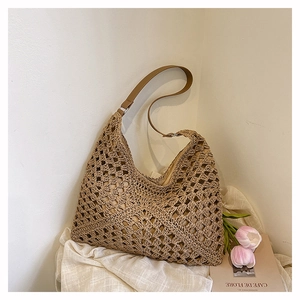 Detail of hollow-out straw woven bag with brown leather strap and white fabric lining