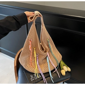 Detail of hollow knit beach tote featuring six colorful spiral tassels on beige cotton rope