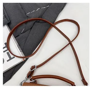 Detail of a brown textured shoulder bag with comfortable strap and silver hardware