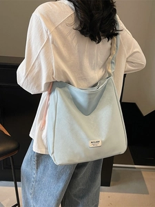 Large capacity sky blue tote bag with pink drawstring and wide shoulder strap shown on model
