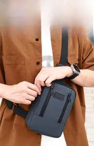 Detail of washed denim sling bag with multi-pocket storage and adjustable strap