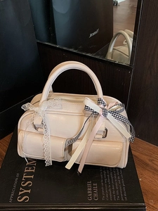 Creamy beige Boston bag with multi-pocket design and decorative ribbon bows