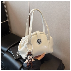 Détail du sac bowling blanc cassé avec fermoir rotatif et charm perlé de dessin animé
