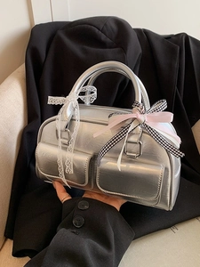 Silver metallic Boston bag with multiple pockets and lace bows in a trendy Y2K style