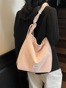 Pink suede large capacity hobo bag worn by model in casual style for daily commute