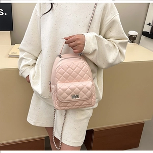Detailansicht eines rosa gesteppten Mini-Rucksacks mit schicken Kettenriemen und Drehverschluss