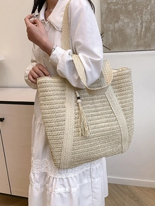 Minimalist straw tote bag with wood bead tassels and wide shoulder straps for women