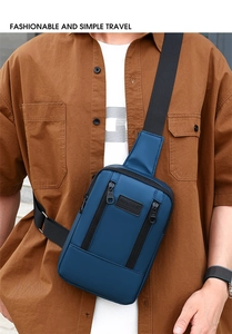 Detail of blue denim sling bag with vertical zippers and black Sport label on the front