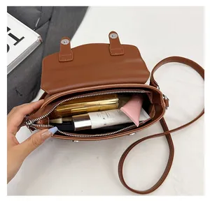 Interior view of brown leather crossbody bag showing spacious storage with zipper pocket