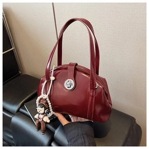 Détail du sac bowling verni bordeaux avec boucle métallique et breloque en perles