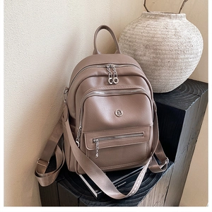 Detail view of taupe lychee grain leather backpack with silver hardware and multi-pockets