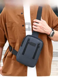 Detail view of dark grey washed denim chest bag with multi-pocket design and sport patch