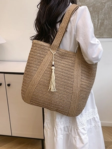 Handmade woven straw tote bag with tassels and shoulder strap for summer beach fashion