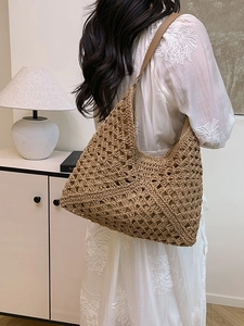 Deep khaki hollow straw hobo bag with geometric weave and light brown shoulder strap