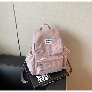 Dettaglio zaino in nylon rosa con coulisse, patta ed etichetta tessuta waswac rules