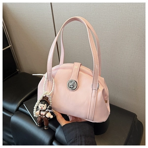 Détail du sac bowling rose brillant avec fermoir argenté et breloque en perles