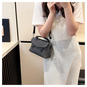 Close-up of deep grey textured mini crossbody bag with round buttons and silver hardware