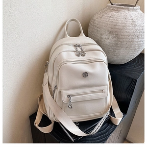 Close-up of cream white backpack with litchi grain leather and silver hardware details