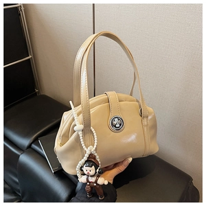 Vue détaillée du sac en cuir crème avec bandoulière perlée et pendentif poupée mignon