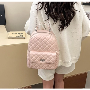 Detail eines rosa gesteppten Mini-Rucksacks mit Metalldrehverschluss und Kettenriemen