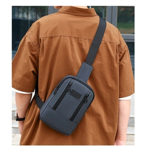 Detail of multi-zipper compartments and logo on washed denim crossbody bag for men