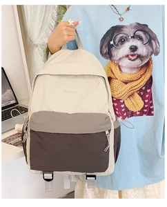 Detail of a lightweight cream and grey travel backpack with side drawstring pocket
