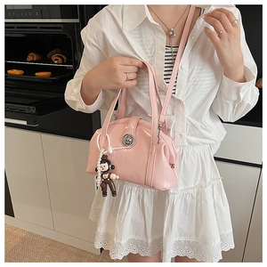 Sac bowling en cuir verni rose avec breloque dessin animé dans un décor moderne
