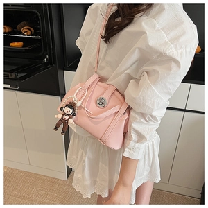 Détail du sac bowling rose clair avec un adorable charm d'ours dans un décor de vie