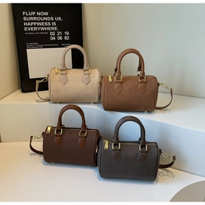 Detail of four colored Boston bags featuring lychee leather texture and golden zippers
