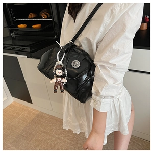 Détail du sac à bandoulière bowling noir avec fermoir en métal et pendentif poupée