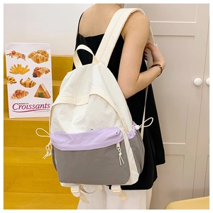 Detail of adjustable drawstring side pockets and buckles on a purple hiking backpack
