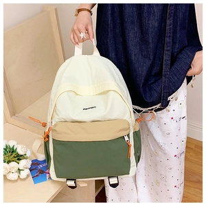 Detail view of tri-color lightweight nylon backpack with drawstring and metal zipper