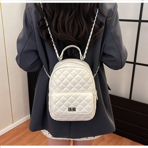 Rückansicht eines weißen gesteppten Mini-Rucksacks mit silbernen Ketten am Modell