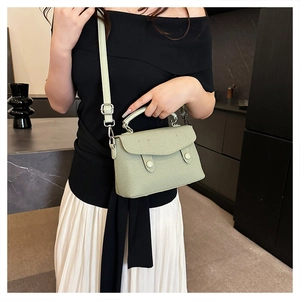 Detail of mint green textured leather crossbody bag styled with a modern outfit