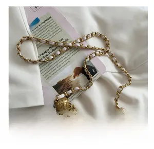 Detail of white quilted crossbody bag with golden chain and adjustable ball buckle