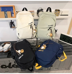 Dettaglio di borse a tracolla leggere da trekking in quattro colori con ciondoli baseball