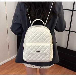 Rückansicht eines weißen gesteppten Rucksacks mit Kettenriemen auf einem grauen Blazer