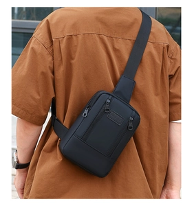 Outdoor shot of a black sporty denim chest bag for men with multiple zipper pockets