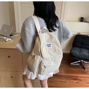 Primo piano dettagliato di uno zaino in nylon beige minimalista con etichetta logo tessuta