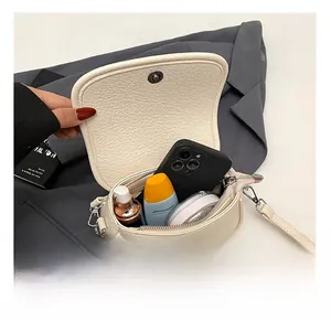 Detailed interior view of white pebbled leather crossbody bag showing its storage capacity