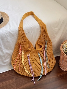 Handmade yellow crochet hobo bag with colorful tassel charms for summer beach vacation