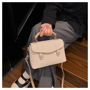 Chic beige woven texture trapezoid handbag with dual snap closure and shoulder strap