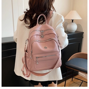 Pink faux leather backpack details featuring multi-zipper layers and adjustable straps