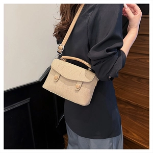 Detailed straw texture crossbody bag with adjustable leather strap and silver buckle hardware